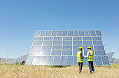 Workers examining solar panel