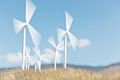 Wind turbines spinning in rural landscape