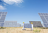 Scientists carrying solar panel