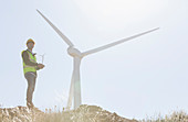 Worker standing by wind turbine