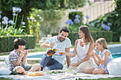 Family enjoying picnic at poolside