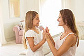 Mother and daughter touching hands