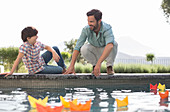 Father and son watching origami boats