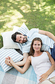 Couple relaxing on picnic blanket