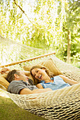 Couple relaxing in hammock outdoors