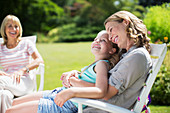 Mother and daughter relaxing in backyard