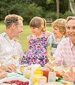 Family eating at table in backyard