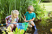 Children fishing together in pond