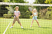 Children playing tennis on grass court