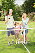 Family together on grass tennis court
