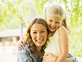 Mother and daughter hugging outdoors