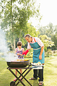 Grandfather and granddaughter grilling