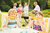 Children eating at table in backyard