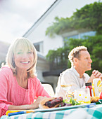 Smiling woman at table in backyard