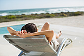Woman sunbathing on lounge chair side