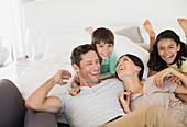 Family laughing and relaxing on sofa