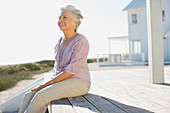 Senior woman sitting at beach house