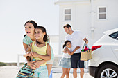 Family hugging in sunny driveway