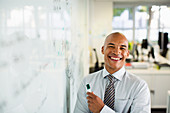 Businessman smiling at whiteboard