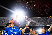 Soccer team celebrating with trophy