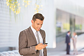 Businessman texting with cell phone