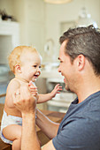 Father and baby laughing in kitchen