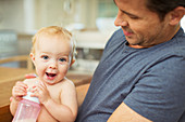 Father and baby sitting in kitchen