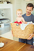 Father carrying baby in laundry basket