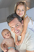 Father and children relaxing on bed