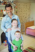 Father and children smiling in bedroom