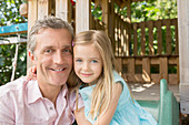 Father and daughter smiling on playset