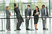 Businessman talking on cell phone in line