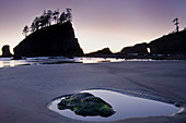 Silhouette of cliffs on beach at low tide