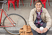 Man drinking coffee on city street