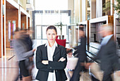 Businesswoman standing in bustling lobby