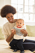 Mother and baby boy playing on sofa