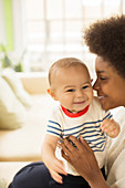 Mother holding baby boy on sofa