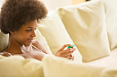 Woman using cell phone on sofa