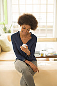 Businesswoman using cell phone on sofa