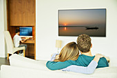 Couple watching television in living room