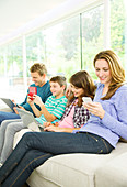 Family using technology on sofa