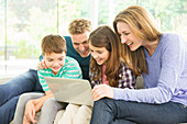 Family using laptop in living room