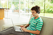 Boy wearing headset and using laptop