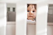 Baby girl sitting up in crib