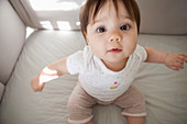 Baby girl sitting up in crib