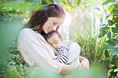 Mother holding baby girl outdoors