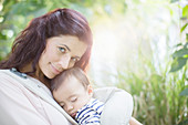 Mother holding baby girl outdoors