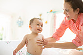 Mother helping baby boy walk