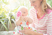 Mother and baby girl playing with flower