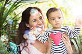 Mother holding baby girl outdoors